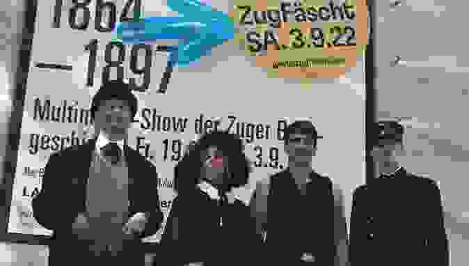 Plakt vom ZugFäscht mit 3 Personen in Kleider von 1864 - 1897.