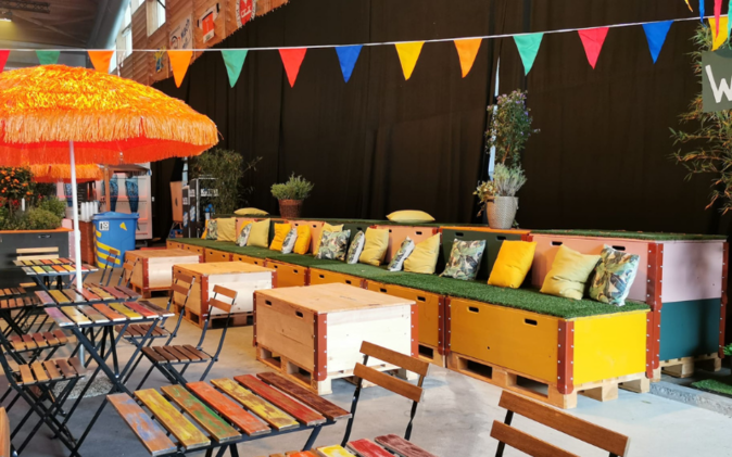 Lounge aus Paletten und Kissen mit Wimpelkette