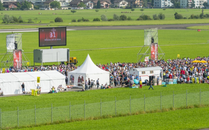 Festmeile mit Zelten und Gästen auf dem Flugplatz in Buochs. 