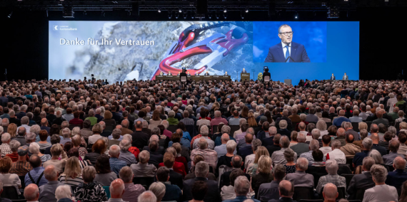 Grosse Leinwand mit Podium und Gästen an der GV der LUKB