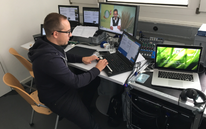 Digitale Delegiertenversammlung von Bio Suisse Technikmitarbeiter am Laptop mit Bildschirmen