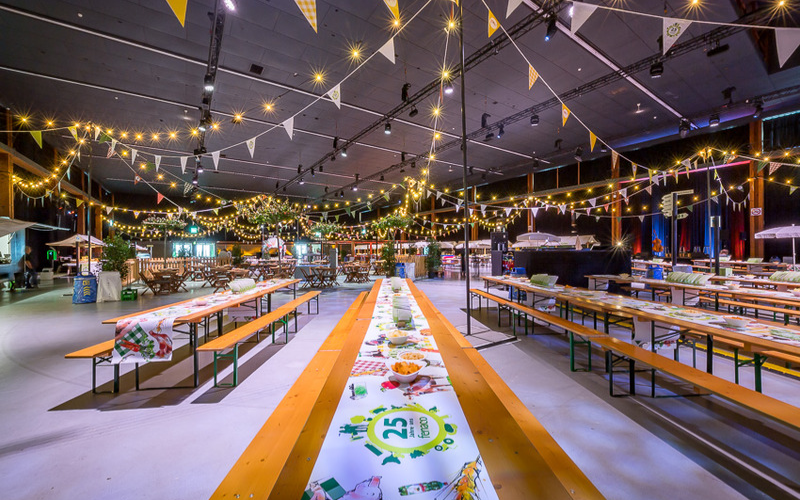 Langer Tisch mit Lämpchen und Fähnchen in der Halle. 