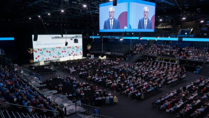 Bossard Arena in Zug an GV der Zuger Kantonalbank mit vielen Gästen. Im Hintergrund Leinwände.  