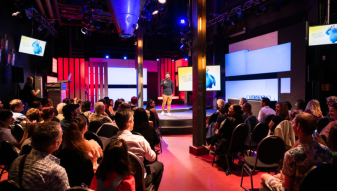 Internationaler Raiffeisen-Jugendwettbewerb Bühne mit Sprecher und Publikum