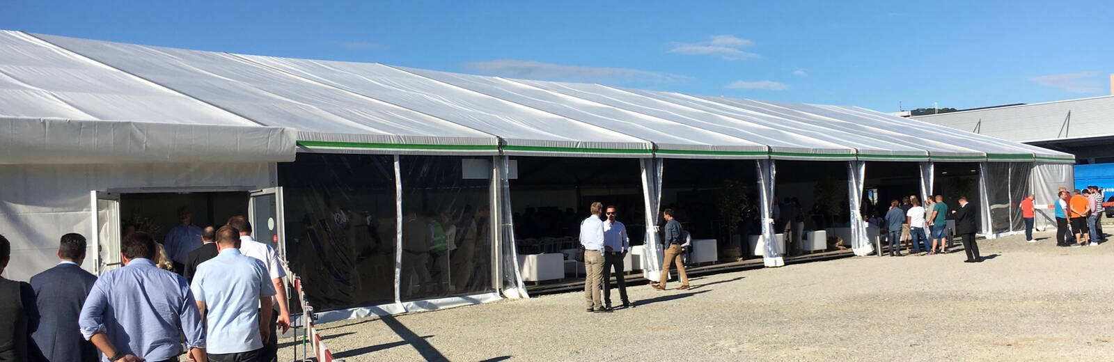 grosses Zelt mit offener Seitenwand, Gäste im und vor dem Zelt