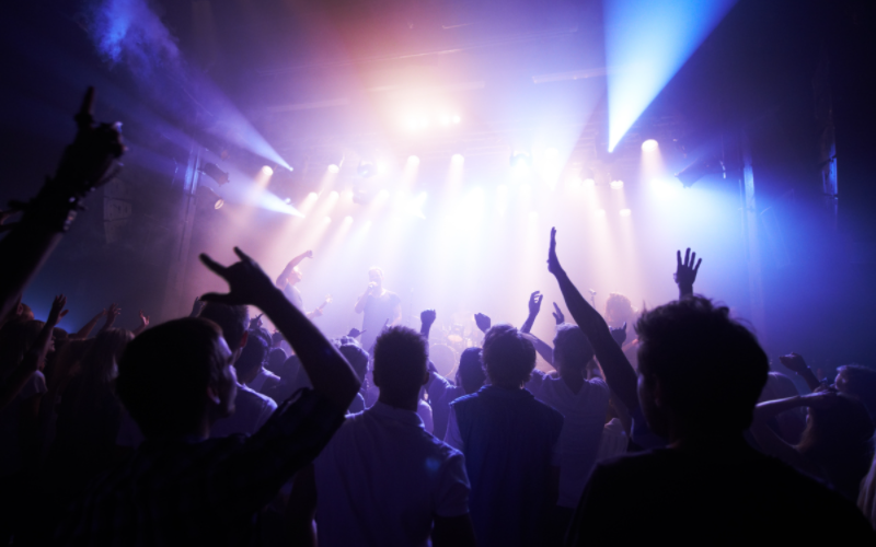 Juni - der Event-Monat Konzertbesucher mit erhobenen Händen an einem Konzert.