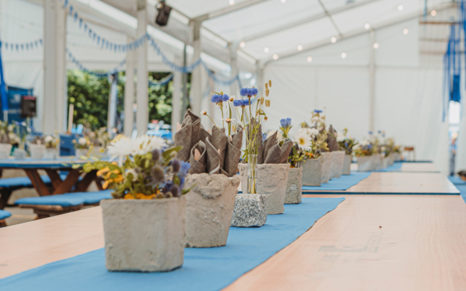 Mitarbeiteranlass zum 100 Jahre Jubiläum  Tischdekoration blaue Blumen in Töpfen