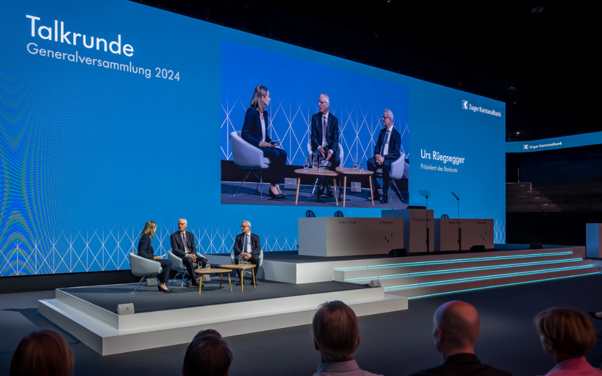 Generalversammlung der Zuger Kantonalbank in der Bossard Arena Gäste und grosse Leinwand mit Podium in der Bossard Arena in Zug.