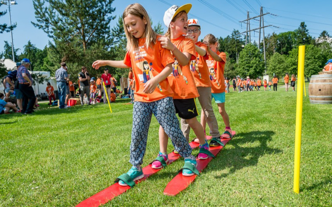 Jugendanlass der Raiffeisen Schweiz Vier Kinder an einem Spiel des Kinder- und Jugendanlasses der Raiffeisen Schweiz.