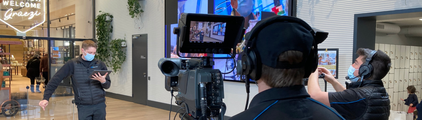 Live-Stream Läderach Chocolatier Suisse Kamera mit Bildschirm bei der Übertragung der Mitarbeiterinformation.