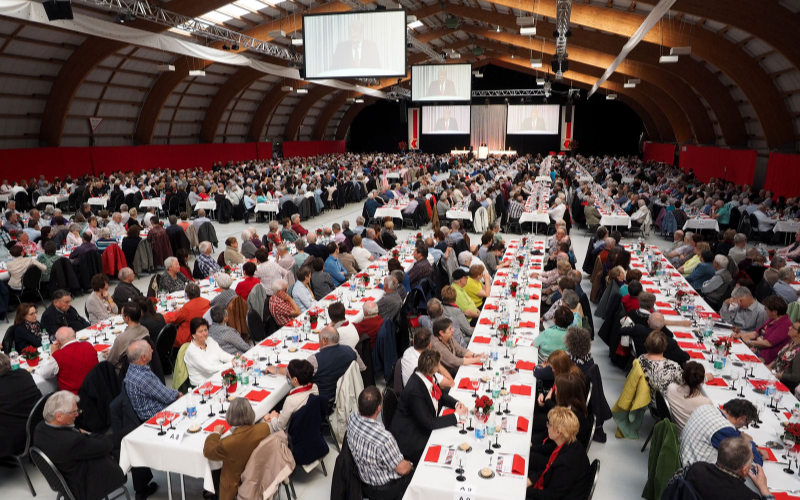 PS-Versammlung der Nidwaldner Kantonalbank Gäste an den Tischen, im Hintergrund Leinwände.