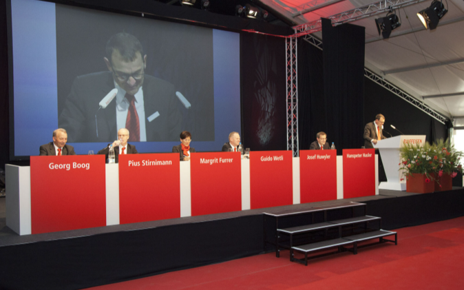 Das Podium mit den Redner und die Leinwand. 