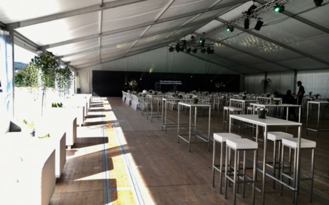 Eingerichtetes Zelt mit Tischen, Stehtischen und Sofas am Eröffnungsanlass. 