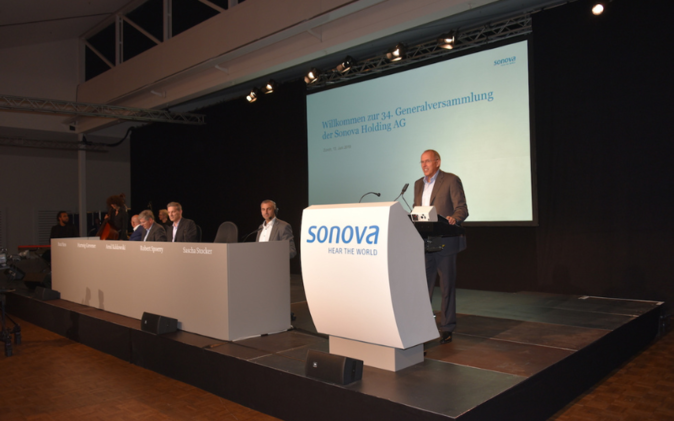 GV Sonova Holding Podium mit Rednerpult und Leinwand.