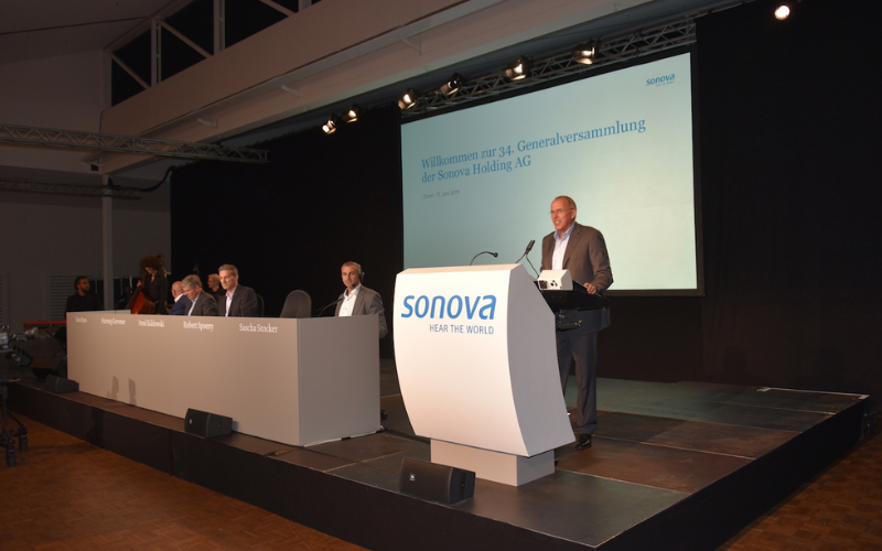 GV Sonova Holding Podium mit Rednerpult und Leinwand.