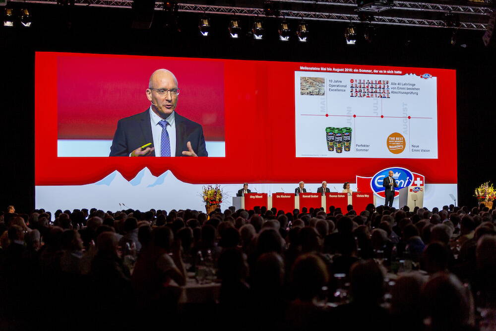 Emmi GV Leinwand und Podium an der GV der Emmi.