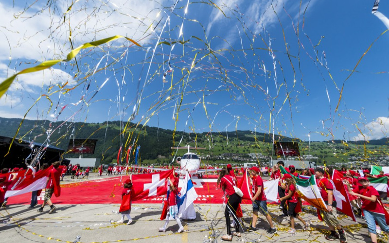 Grossanlass Rollout PC-24 Luftschlangen und Personen mit Fahnen vor dem PC-24
