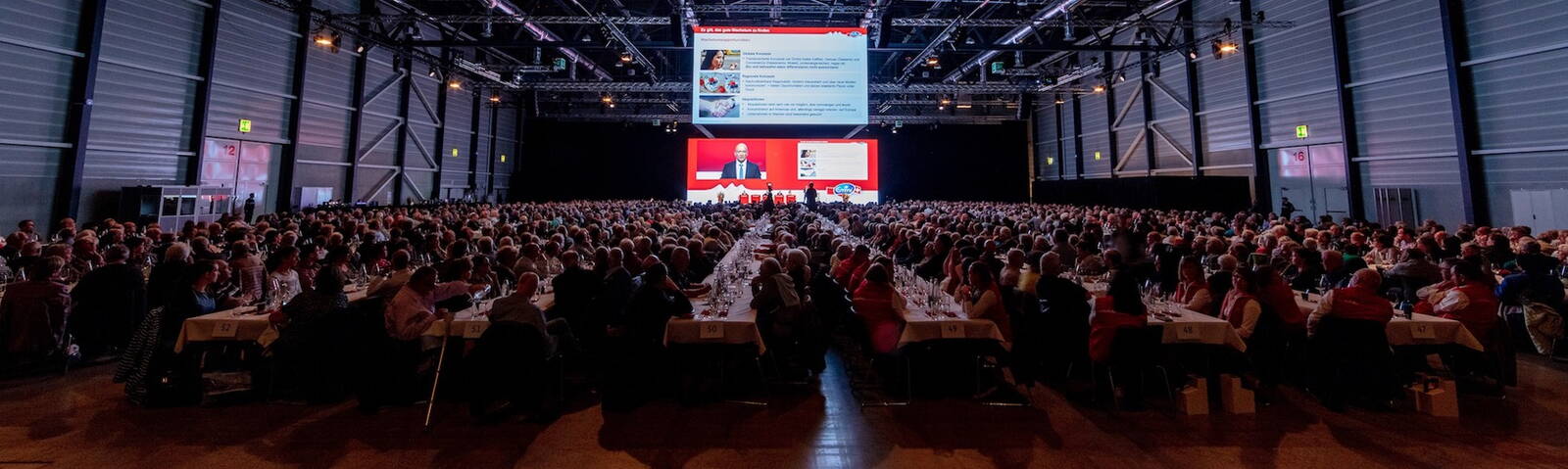 GV Emmi AG Leinwand mit Gästen an der GV der Emmi AG.