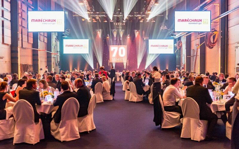 Festlich gekleidete Gäste in der wunderbar hergerichteten Werfthalle der SGV in Luzern.