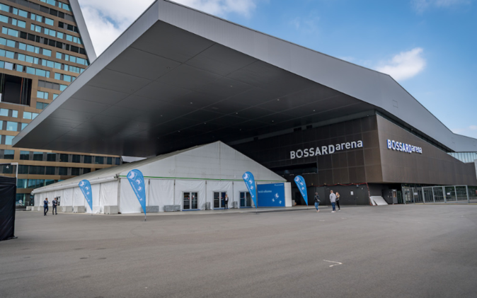 Bossard Arena in Zug von Aussen mit Zelt unter dem Vordach. 