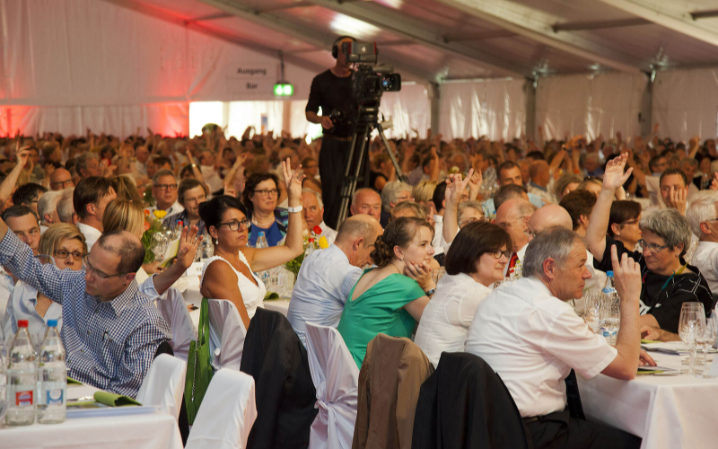 GVs und Delegiertenversammlungen der Raiffeisen schweizweit Abstimmung während GV in einem Zelt.