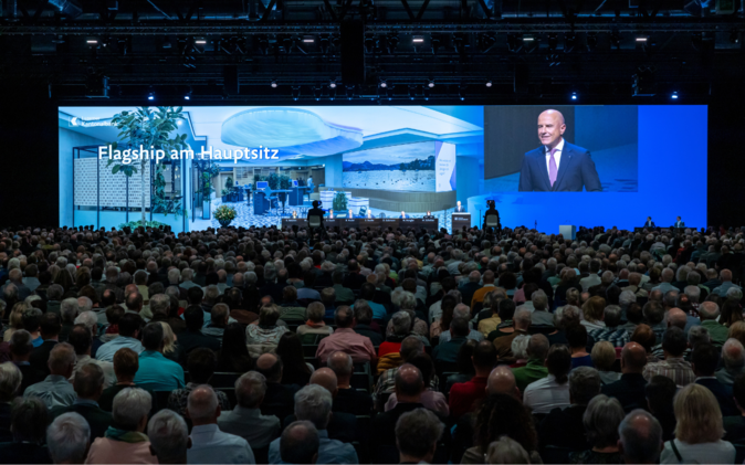GV Luzerner Kantonalbank Grosse Leinwand und Podium mit vielen Gästen an der Generalversammlung der Luzerner Kantonalbank.