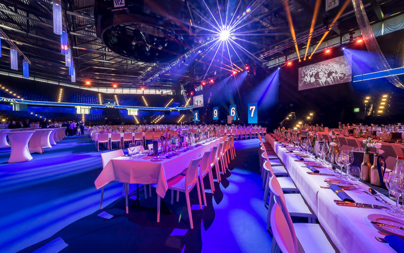 Jubiläumsanlass EVZ Feierlich hergerichtete Halle mit gedeckten Tischen.