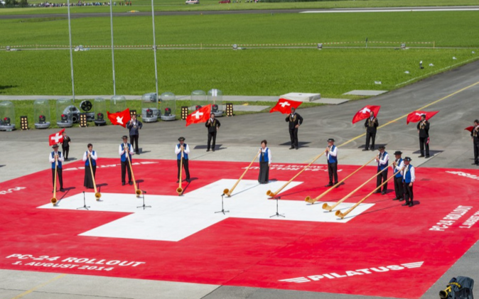 Grossanlass Rollout PC-24 20 x 20 m grosses Schweizer Kreuz am Boden mit Alphorn-Bläser und Fahnenschwinger.