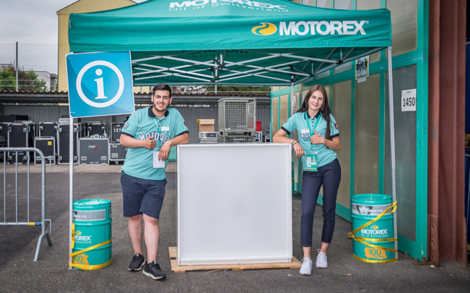 Jubiläumsfestival Motorex Informationsstand mit zwei Mitarbeitenden.